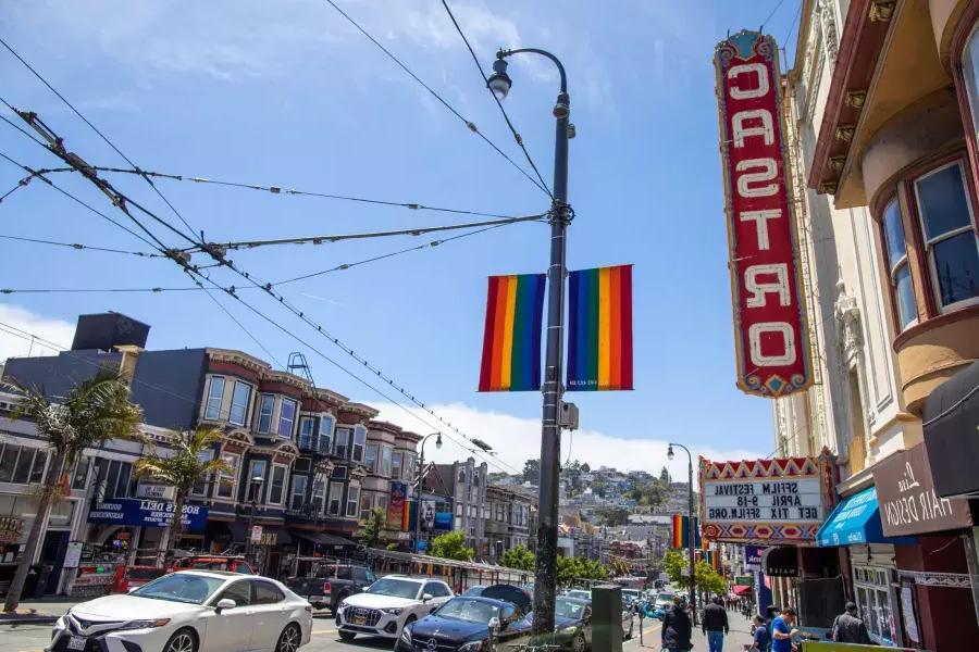 Le quartier Castro de San Francisco, 卡斯特罗剧院的展板和彩虹旗在前景.