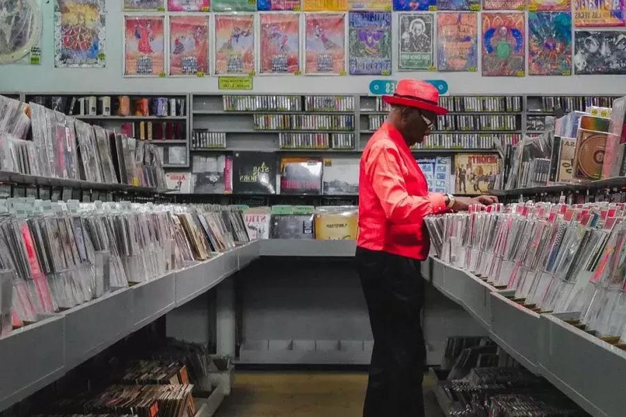 一个穿红夹克的男人在贝博体彩app的变形虫唱片公司买唱片。.